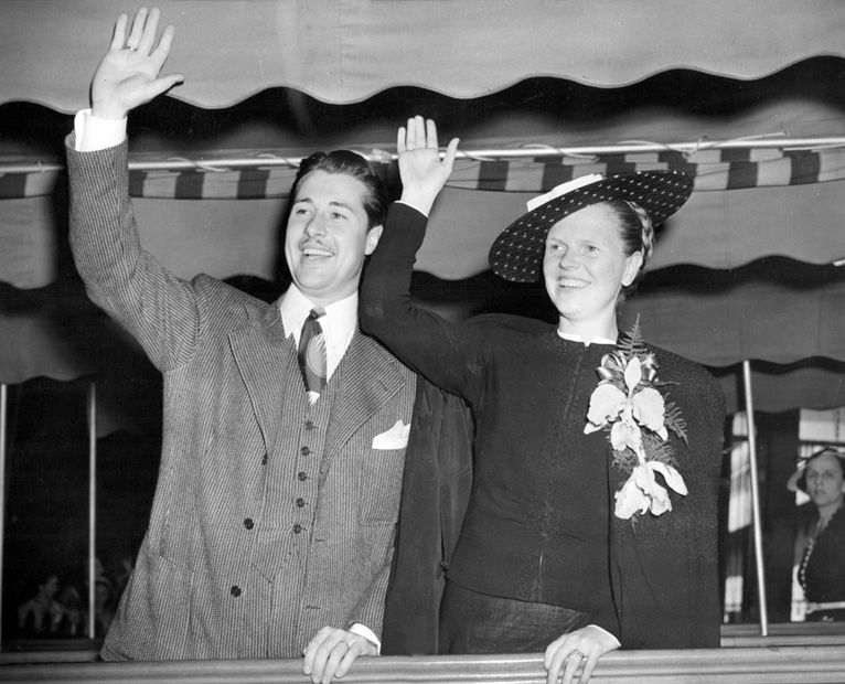 Photo of Don Ameche and Honore Prendergast waving from the deck of the Queen Mary