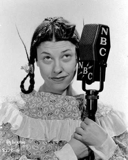 Judy Canova posing in pigtails with an NBC Radio microphone