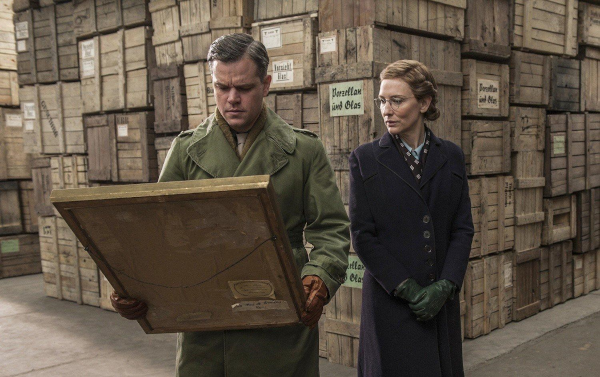 Matt Damon examing a painting in a warehouse as Cate Blanchett observes in the 2014 movie Monuments Men